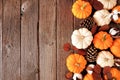 Fall side border of orange and white pumpkins with autumn decor over a rustic dark wood background