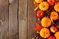 Fall side border with pumpkins, leaves and apples over a rustic dark wood background