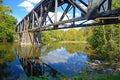 A railroad tressel reflects in blue waters.