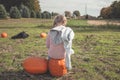 Fall themed photo of a little girl in a pumpkin patch