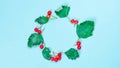 Fall trendy. Dried leaves, green leafs, red fruits Rowans in shape circle isolated on pastel blue background. Blank