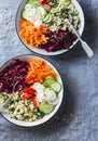 Fall vegetarian buddha bowl. Bulgur, spinach, beets, carrots, cucumbers, tomatoes, daikon - balanced healthy eating lunch. On a bl