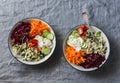 Fall vegetarian buddha bowl. Bulgur, spinach, beets, carrots, cucumbers, tomatoes, daikon - balanced healthy eating lunch. On a gr