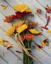 Fall flowers tied together on white wood