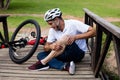 Fallen cyclist holding his injured knee