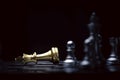 Fallen of golden king chess among silver chess figure. Defeat and loss of business competition and marketing strategy planing