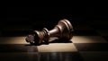 Fallen king chess piece on dark chessboard in dramatic lighting Royalty Free Stock Photo