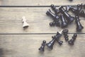 Fallen king pieces surrounded by the other color chess pieces on wooden table Royalty Free Stock Photo