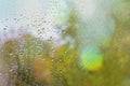 Fallen leaf stuck to the window that gets wet from rain drops. Warm look out the window for autumn.