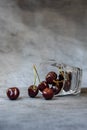 Fallen transparent glass with ripe sweet cherries