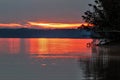 Fallen tree pointing to early morning red sunrise on Rend Lake, Illinois Royalty Free Stock Photo