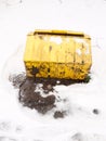Fallen turned over yellow grit box salt outside snow storm Royalty Free Stock Photo
