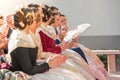 Falleras in a public event sitting clapping. Hairstyle and dress typical of the parties of the Fallas of Valencia