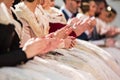 Falleras seated clapping at a public event in the city. Group of unfocused falleras