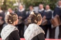 Falleras seen from behind. Detail photograph of the typical hairstyle of the Fallas. Musicians blurred in the background