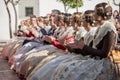 Falleras sitting facing the stage at a public event in the city. tail of the hairstyles and classic dresses of this celebration