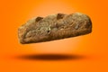 Falling Australian dark bread on an orange background