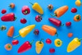 Falling bell pepper and tomatos on blue background. Flying colorful sweet peppers. Banner. Vegetable pattern for packaging design Royalty Free Stock Photo