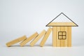Falling blocks of wood hit solid blocks in shape of house. domino blocks fall on miniature house Royalty Free Stock Photo