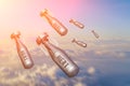 Falling bombs weapons charges dropped from a fighter combat aircraft high in the sky, a view of clouds and land. Royalty Free Stock Photo