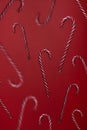 Falling candy canes on red background. Candies levitation christmas trendy pattern Royalty Free Stock Photo