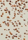 Falling coffee beans isolated on vertical background. Flying defocusing coffee grains