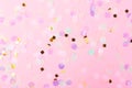 Falling colorful confetti on pink background