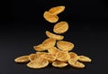 Falling corn flakes on black background, full depth of field