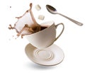 Falling Cup with coffee splash, cubes of refined sugar and teaspoon on a white Royalty Free Stock Photo