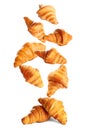 Falling delicious fresh baked croissants on white background. French