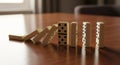 Falling dominoes creating chain reaction on wooden surface Royalty Free Stock Photo