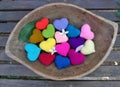 Falling flower and leaf on colourful hearts in wooden tray in the garden Royalty Free Stock Photo