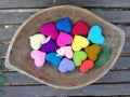 Falling flower and leaf on colourful hearts in wooden tray in the garden Royalty Free Stock Photo