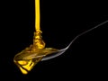 Falling and flowing honey on a spoon isolated on black with clipping path Royalty Free Stock Photo