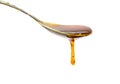 Falling and flowing honey on a spoon isolated on white with clipping path.