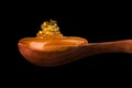 Falling and flowing honey on a wooden spoon isolated on black with clipping path Royalty Free Stock Photo