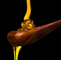 Falling and flowing honey on a wooden spoon isolated on black with clipping path Royalty Free Stock Photo