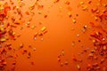 falling gold glitter foil confetti, on orange background, holiday and festive fun concept Royalty Free Stock Photo