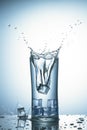 Falling ice cubes in a glass of water with splash Royalty Free Stock Photo