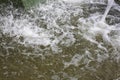 Falling jet fountain in bowl water on bright sunny day, creating movement water in bowl, waves, spray, foam. Royalty Free Stock Photo