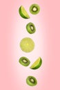 Falling limes and kiwi isolated on a pink background with clipping path. Flying fruits Royalty Free Stock Photo