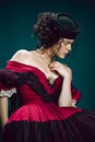 Young woman as Anna Karenina on dark blue background. Retro style, comparison of eras concept.