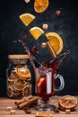 Falling mulled wine ingredients, citrus fruits, cinnamon and star anise fly from a height and create splashes. A cauldron of