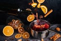 Falling mulled wine ingredients, citrus fruits, cinnamon and star anise fly from a height and create splashes. A cauldron of