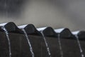 Falling rain from wavy metal sheet rooftop