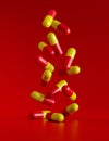 falling red-yellow pills on a red surface Royalty Free Stock Photo