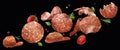 Falling sliced salami isolated on black background