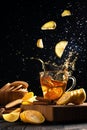 falling slices of lemons into a mug with hot tea, splashes in different directions Royalty Free Stock Photo