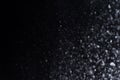 Falling snow at night. Bokeh lights on black background, flying snowflakes in the air. Overlay texture. Snowstorm. Royalty Free Stock Photo