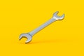 Falling spanner on yellow background. Metal wrench in workshop. Repair and maintenance tool. Royalty Free Stock Photo